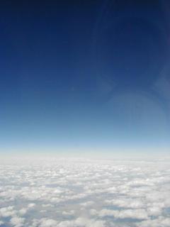 Blue sky!.  Just the horizon for a fun photo, but you can see the reflection of my camera in the plane window<br>Location: Over California